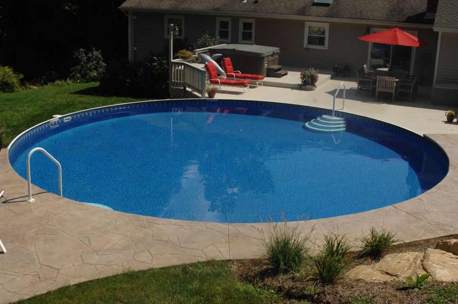 Outdoor pool environment with above ground pool and coordinated hardscape